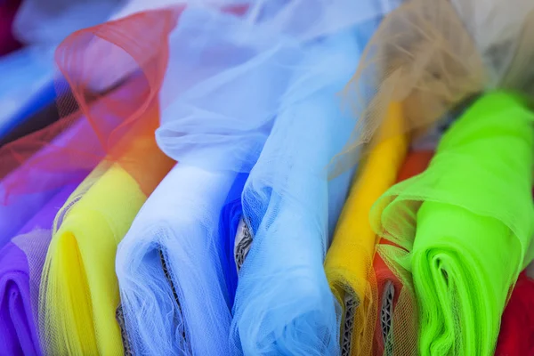 Rolls of multi-colored fine fabrics on a counter of shop — Stock Photo, Image