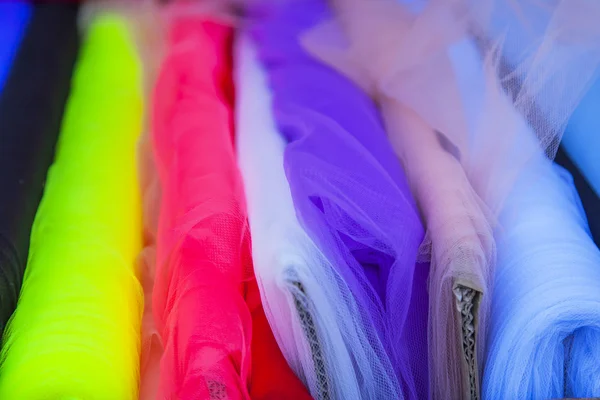 Rolls of multi-colored fine fabrics on a counter of shop — Stock Photo, Image