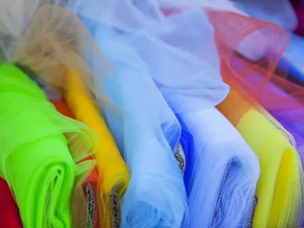 Rolls of multi-colored fine fabrics on a counter of shop — Stock Photo, Image