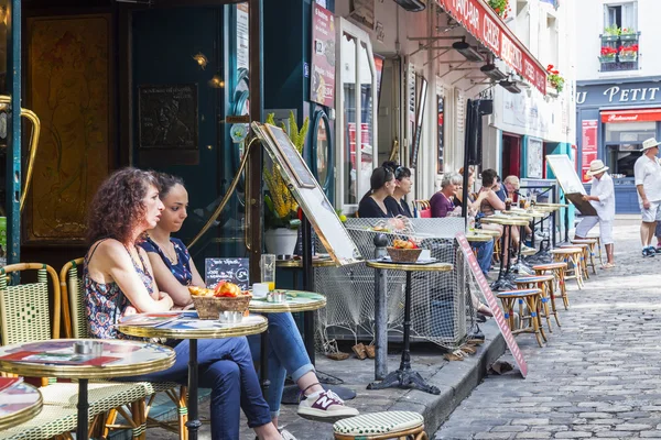 París, Francia, 8 de julio de 2016. Montmartre, la gente come y descansa detrás de mesitas de café en la acera — Foto de Stock