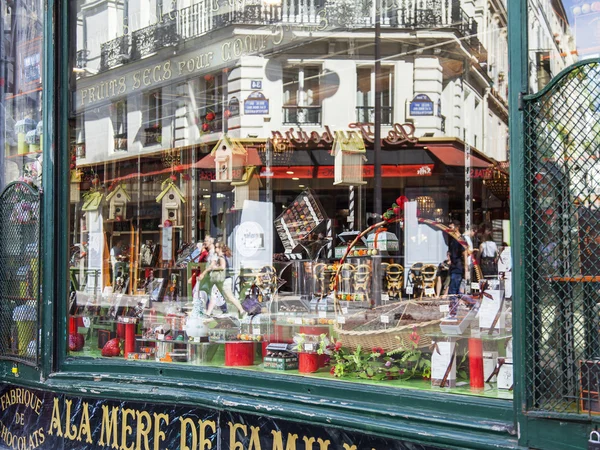 PARIS, FRANÇA, em 8 de julho de 2016. Vista urbana típica. a rua pitoresca reflete-se em uma janela de demonstração da loja — Fotografia de Stock