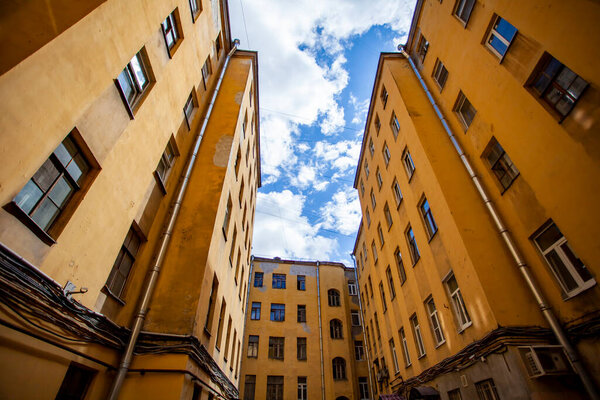 St. Petersburg, Russia, June 13, 2020. Typical for the city courtyard-well on Rubinstein street, bottom up view. A piece of sky is visible between the houses
