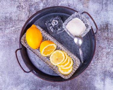 Taze limon ve şeker cam kasede metal bir tabakta
