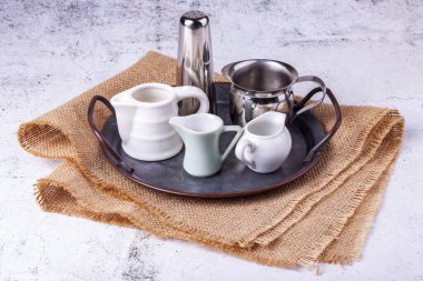 Antika metal tepside krema ve süt için üç porsiyon sürahi.