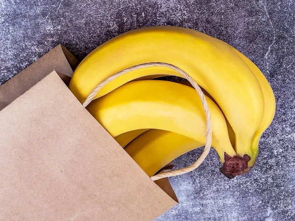 Manojo Plátanos Una Bolsa Papel Sobre Mesa — Foto de Stock