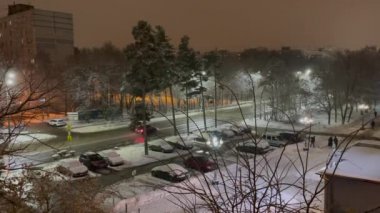 Pushkino, Rusya, 2 Ocak 2021. Karla kaplı bir caddenin penceresinden ve yerleşim alanındaki bir otoparktan görüntü. Kar yağıyor. Gece vakti.