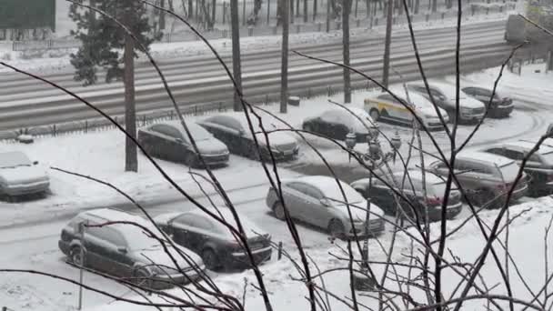 Pushkino, Rusia, 2 de enero de 2021. Vista desde la ventana de una calle cubierta de nieve y un estacionamiento en una zona residencial. Nieva.. — Vídeo de stock
