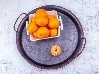 Eski metal bir plaka üzerinde mandalinalar.