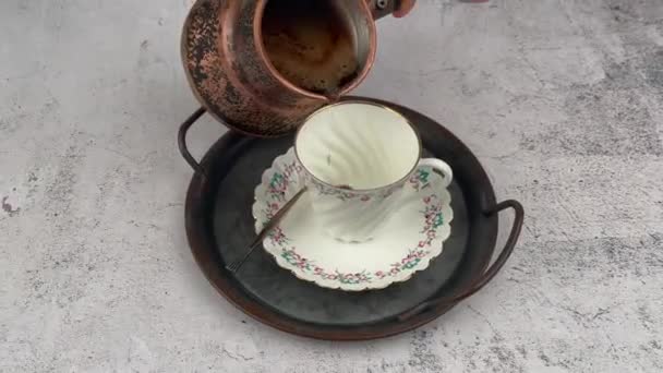 Черный кофе в винтажной меди цеце наливая в чашку кофе — стоковое видео