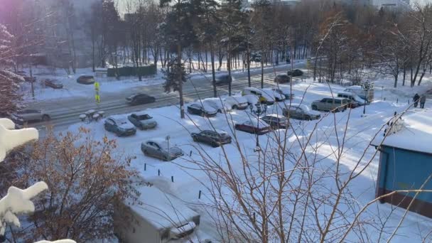 2021年1月14日，俄罗斯普希金诺。从白雪覆盖的街道和住宅区的停车场的窗口观看。Snowing. — 图库视频影像