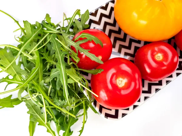 健康食品 長方形のプレート上に赤と黄色のトマトとアルグラの葉 — ストック写真