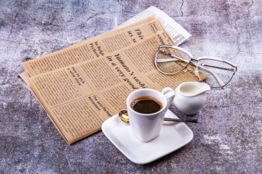 Pushkino, Rusya, 10 Aralık 2020. Eski gazete ve beyaz porselen kahve fincanı bir kafede masanın üstünde.