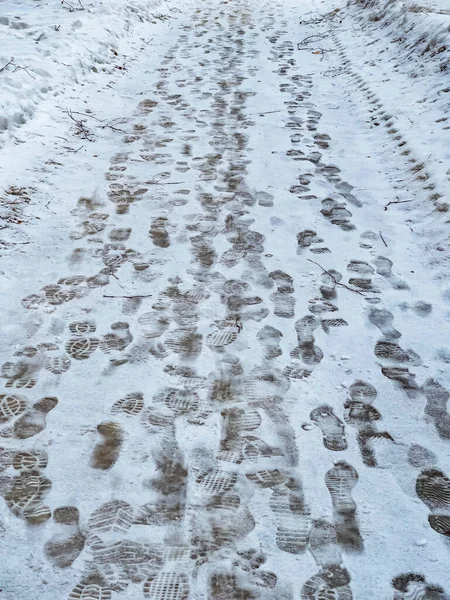 Footprints of boots on a track covered with snow in winter