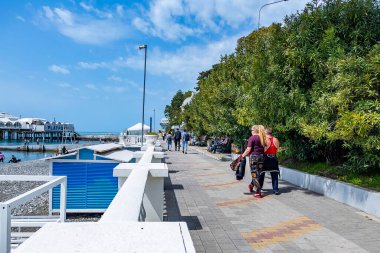 Sochi, Rusya, 13 Nisan 2021. İnsanlar güneşli bir bahar gününde setin üzerinde yürürler.