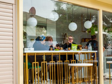 Sochi, Rusya, 18 Nisan 2021. Resimli duvar seti. İnsanlar deniz kıyısındaki kafede dinlenip yemek yiyor.