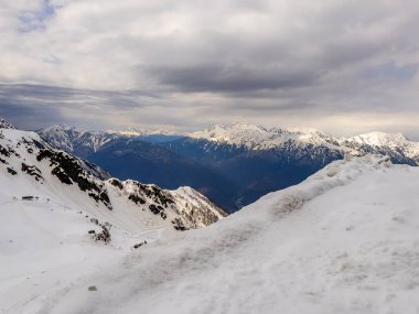 Rosa Khutor tatil beldesinde karla kaplı tepeleri olan resimli dağ manzarası.