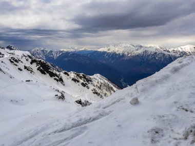 Rosa Khutor tatil beldesinde karla kaplı tepeleri olan resimli dağ manzarası.
