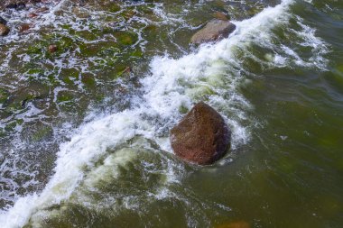 Deniz dalgası ve ıslak taşlar, doğal arka plan.