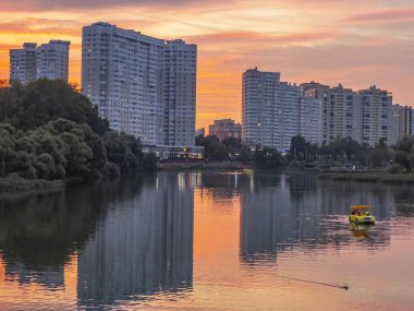 Pushkino, Rusya, 29 Ağustos 2021. Serebryanka nehrinin kıyısındaki yeni çok katlı evler ve onun yansıması. Gün batımı zamanı