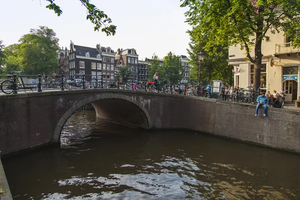 Amsterdam, Nederland, op 10 juli 2014. typisch stedelijke weergave met oude gebouwen aan de oever van het kanaal — Stockfoto