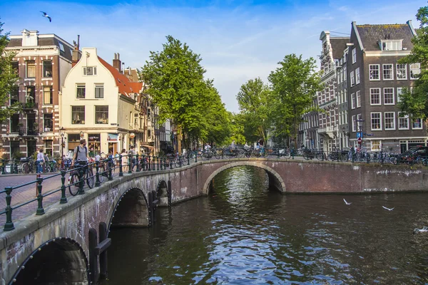 Amsterdam, Nederland, op 10 juli 2014. typisch stedelijke weergave met oude gebouwen aan de oever van het kanaal — Stockfoto