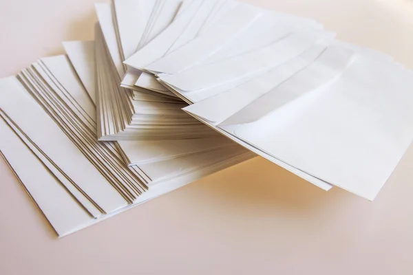 Hromadu bílé poštovní obálky na stůl — Stock fotografie