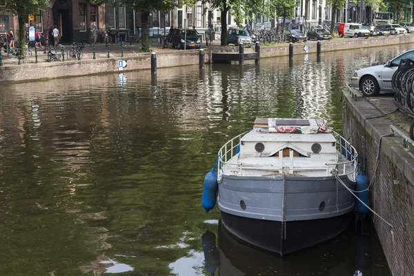 Amsterdam, Nederland, op 10 juli 2014. typisch stedelijke weergave met oude gebouwen aan de oever van het kanaal — Stockfoto