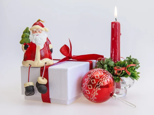 Cadeau du Nouvel An dans une boîte en carton blanc, bijoux pour sapin et bougie allumée — Photo