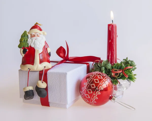 Cadeau du Nouvel An dans une boîte en carton blanc, bijoux pour sapin et bougie allumée — Photo