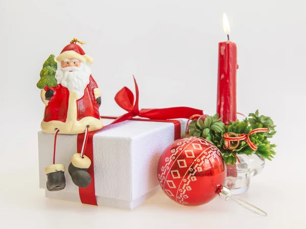 Cadeau du Nouvel An dans une boîte en carton blanc, bijoux pour sapin et bougie allumée — Photo