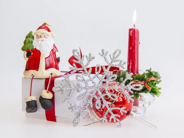 Cadeau du Nouvel An dans une boîte en carton blanc, bijoux pour sapin et bougie allumée — Photo