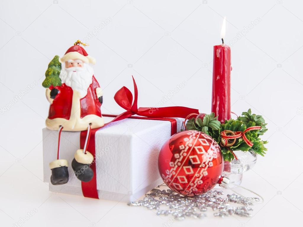 New Year's gift in a white cardboard box, jewelry for a fir-tree and the burning candle