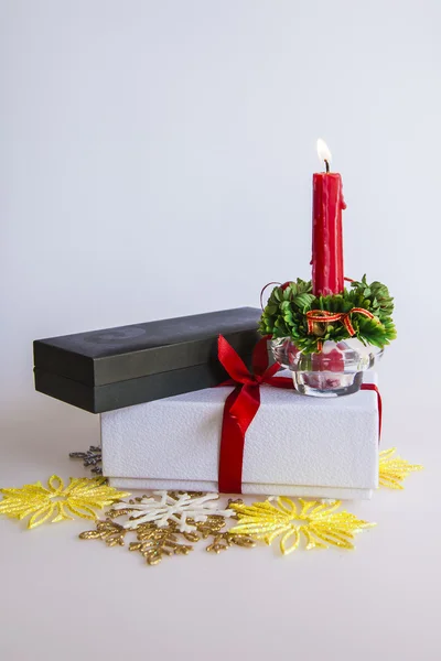 O presente de Ano Novo em uma caixa de papelão branca, jóias de um abeto e uma vela ardente — Fotografia de Stock