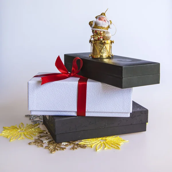 Novoroční dárek v bílé krabici, šperky pro jedle a hořící svíce — Stock fotografie