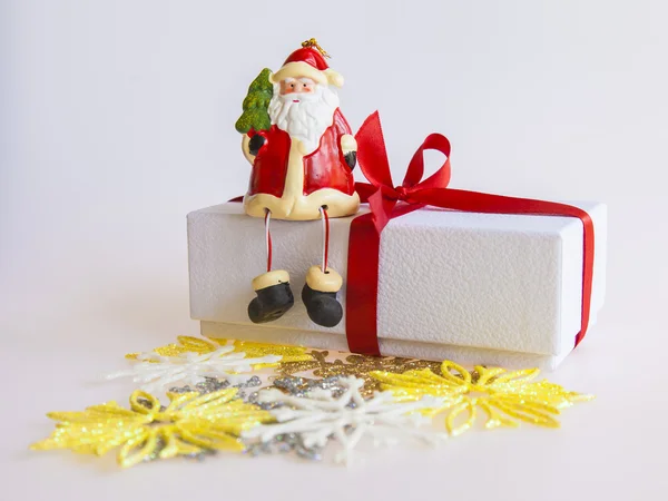 Cadeau du Nouvel An dans une boîte en carton blanc, bijoux pour sapin et bougie allumée — Photo