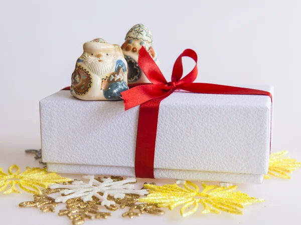 New year's gift in een witte kartonnen doos, sieraden voor een spar-tree en de brandende kaars — Stockfoto
