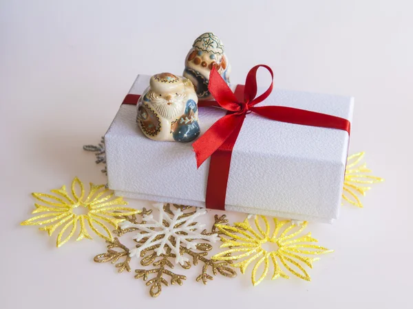 Cadeau du Nouvel An dans une boîte en carton blanc, bijoux pour sapin et bougie allumée — Photo