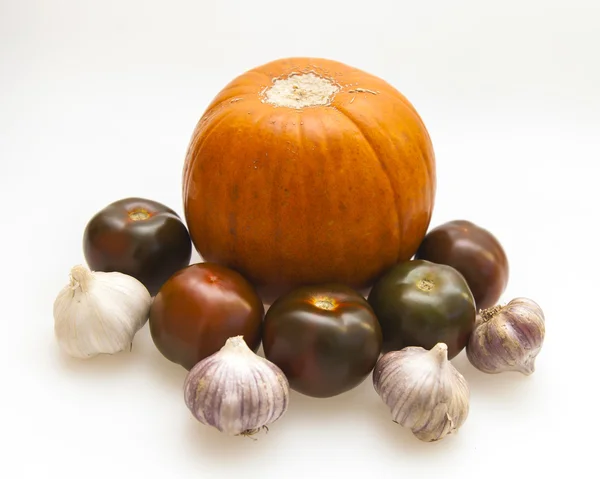 Orange pumpkin, black tomato, garlic for salad — Stock Photo, Image