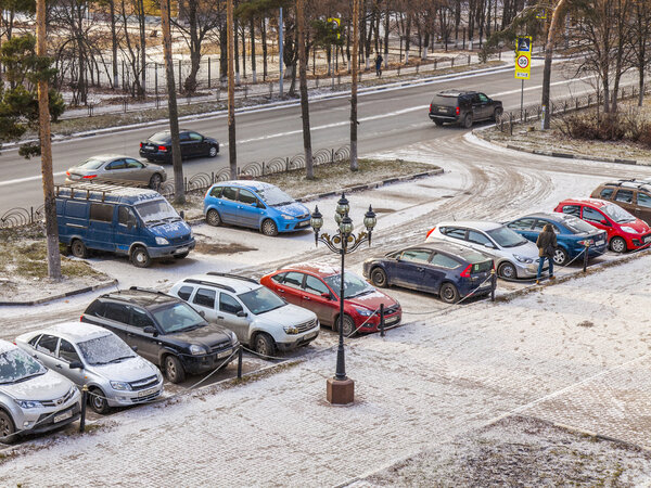 Пушкино, Россия, 17 ноября 2014 года. Первый снег в городе. Автомобили стоят на парковке в населенном массиве
