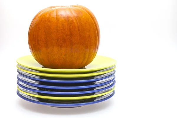 Оранжевая тыква и куча тарелок — стоковое фото