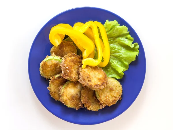Die in Crackern gebratenen Zucchini-Scheiben mit Salat und Paprika auf einem blauen Teller — Stockfoto
