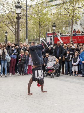 Paris, France, on May 1, 2013. Tourists see a performance of street acrobats on the Champs Elysée