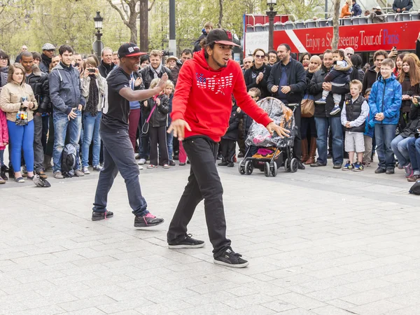 Paris, France, on May 1, 2013. Tourists see a performance of street acrobats on the Champs Elysée — Stockfoto