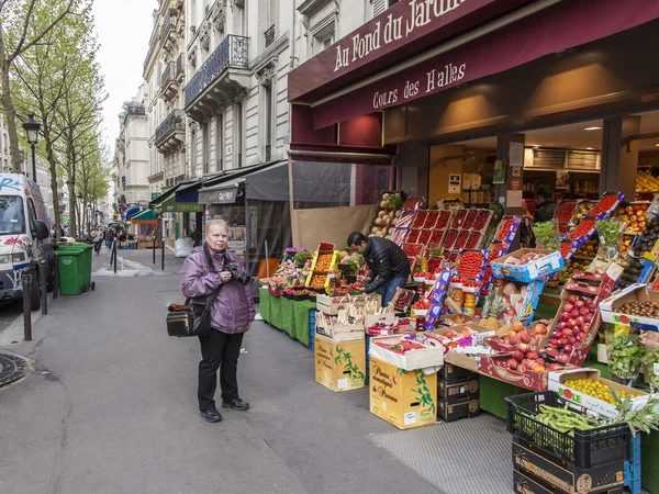 Paris, France, le 4 mai 2013. Les touristes âgés photographient légumes et fruits sur un comptoir du marché de rue — Photo