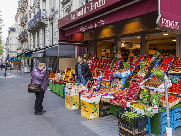 Paris, France, le 4 mai 2013. Les touristes âgés photographient légumes et fruits sur un comptoir du marché de rue — Photo