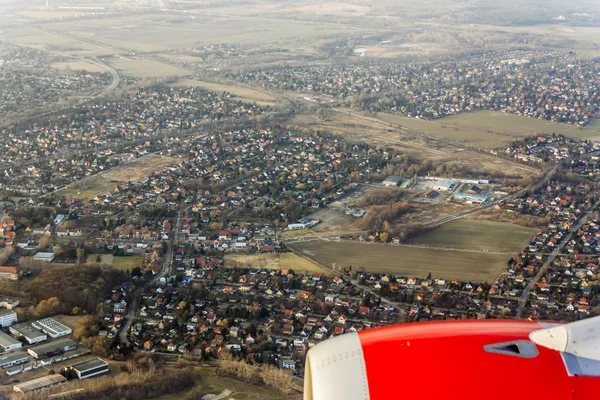 Onun kanat ve toprak yüzeyi üzerinde uçan uçağın penceresinden görüntülemek — Stok fotoğraf