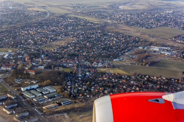 Vista desde la ventana del avión volador en su ala y la superficie de tierra — Foto de Stock