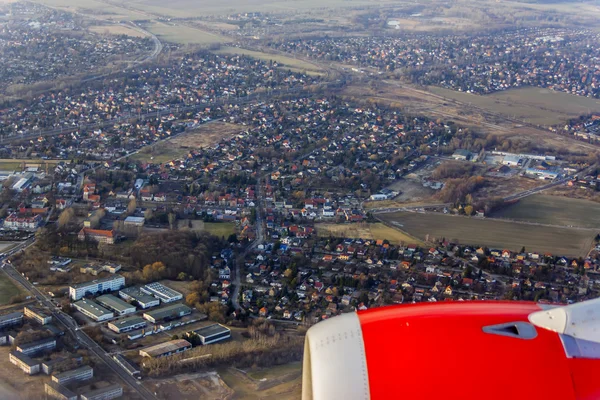 Utsikt från fönstret i det flygande planet på hans wing och jorden yta — Stockfoto