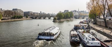 Typical city landscape. A view of Seine, its embankments and the moored inhabited ships. clipart