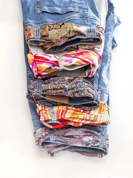 Jeans delle donne di varie ombre con cinture variopinte di seta su una vetrina di negozio — Foto Stock